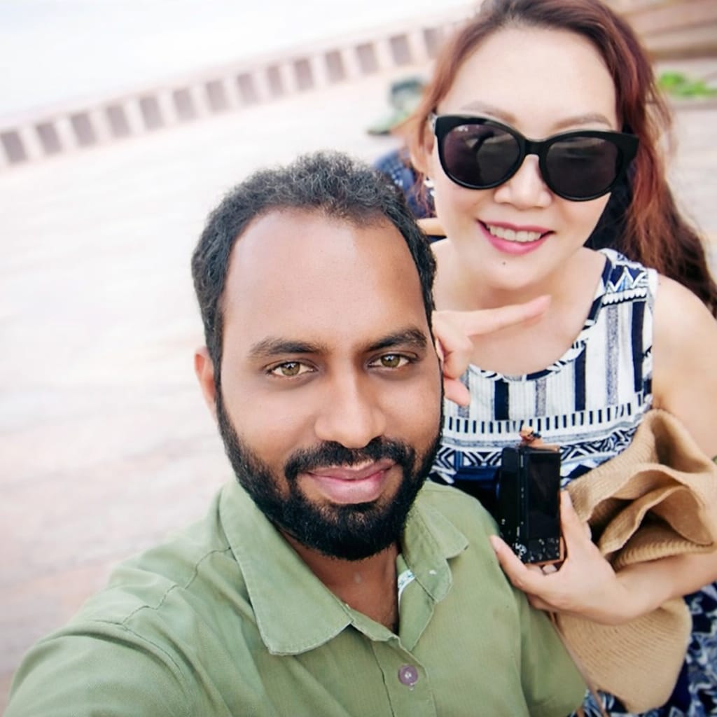 Two travellers laughing on a coracle during Tungabhadra River sunset Hampi
