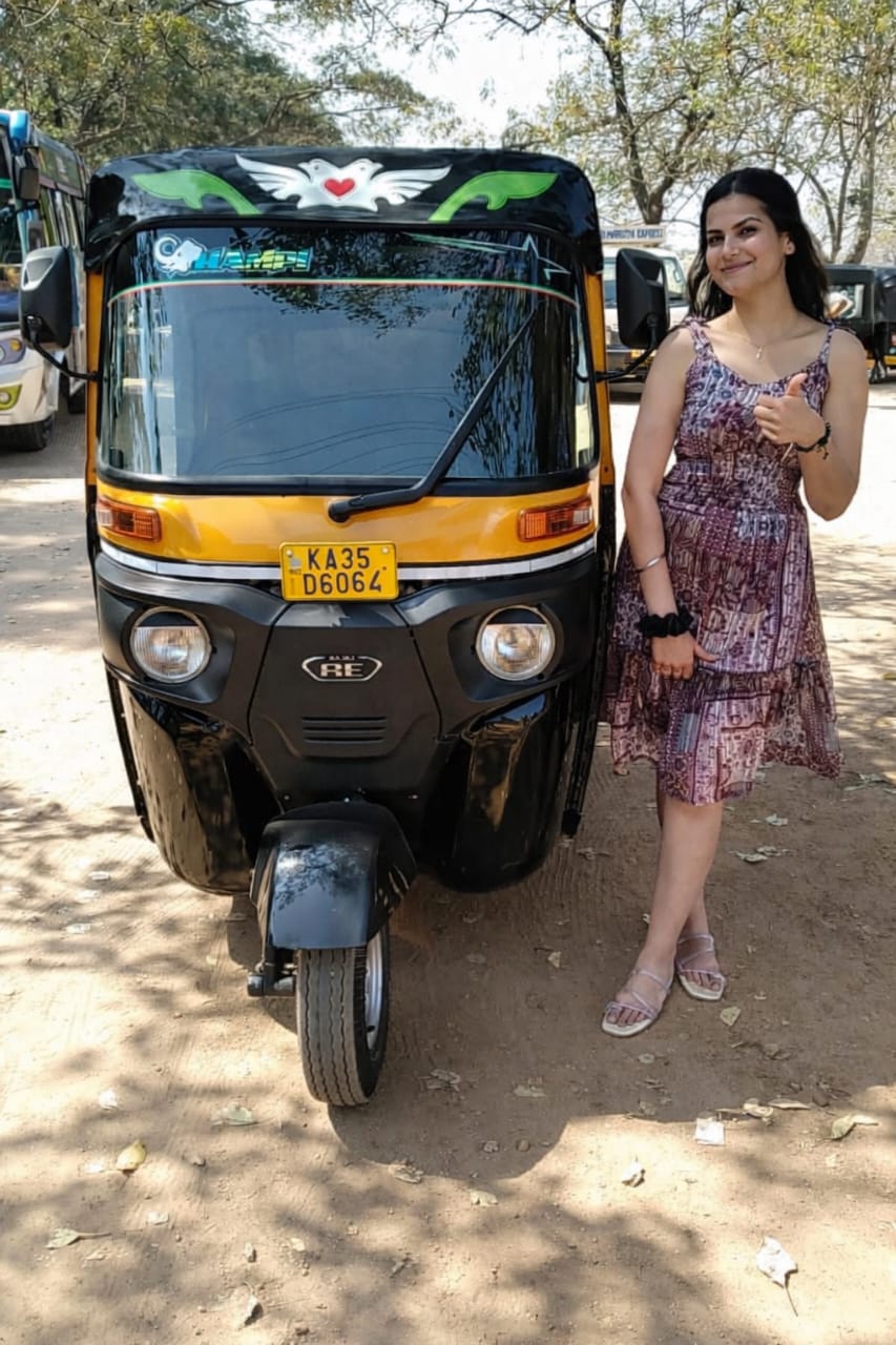 International couple posing with Rocky's auto rickshaw in Hampi